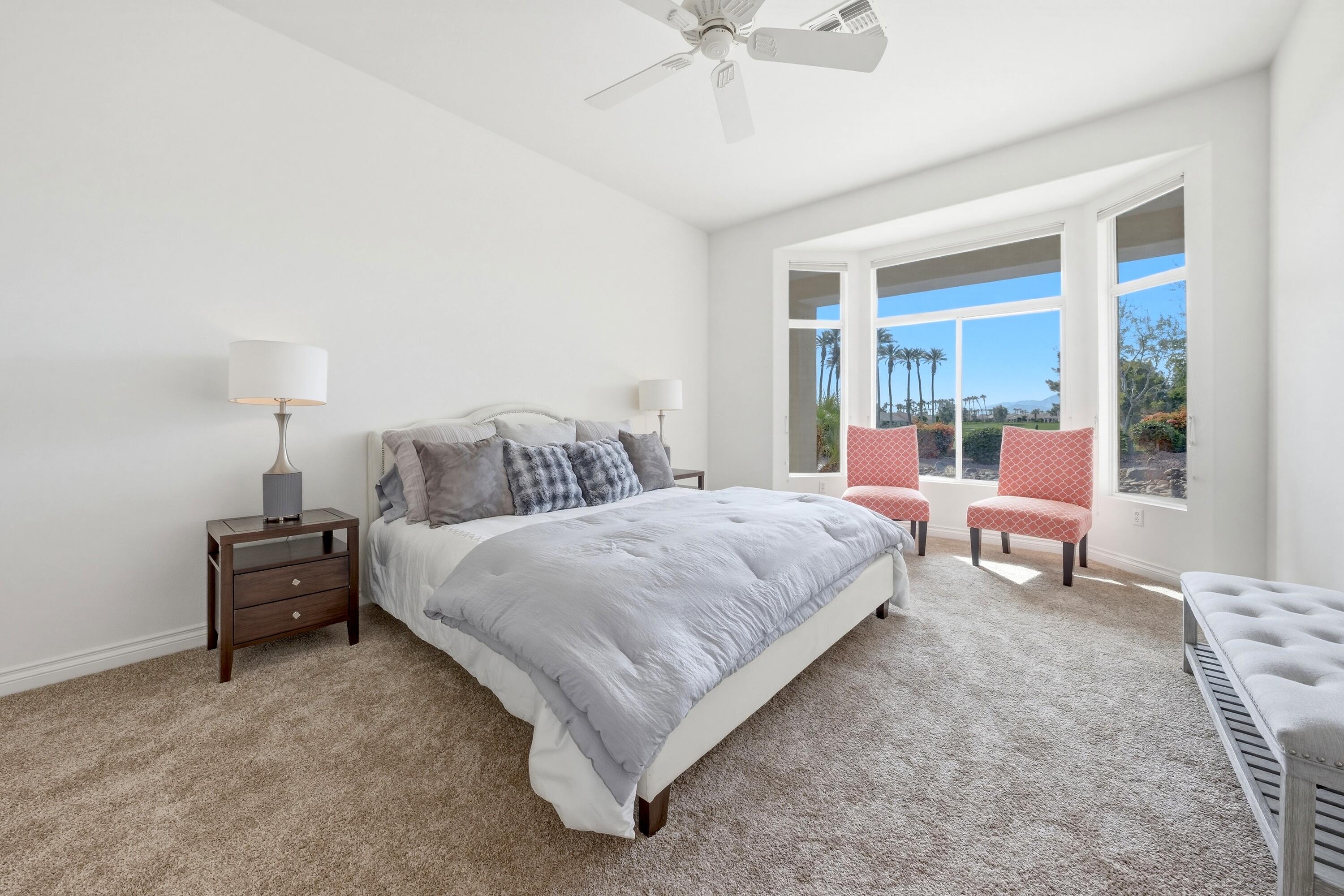 35440 Moorbrook Road Palm Desert, CA 92211 - Photo 19 of 32 a bedroom with a large bed and a chandelier
