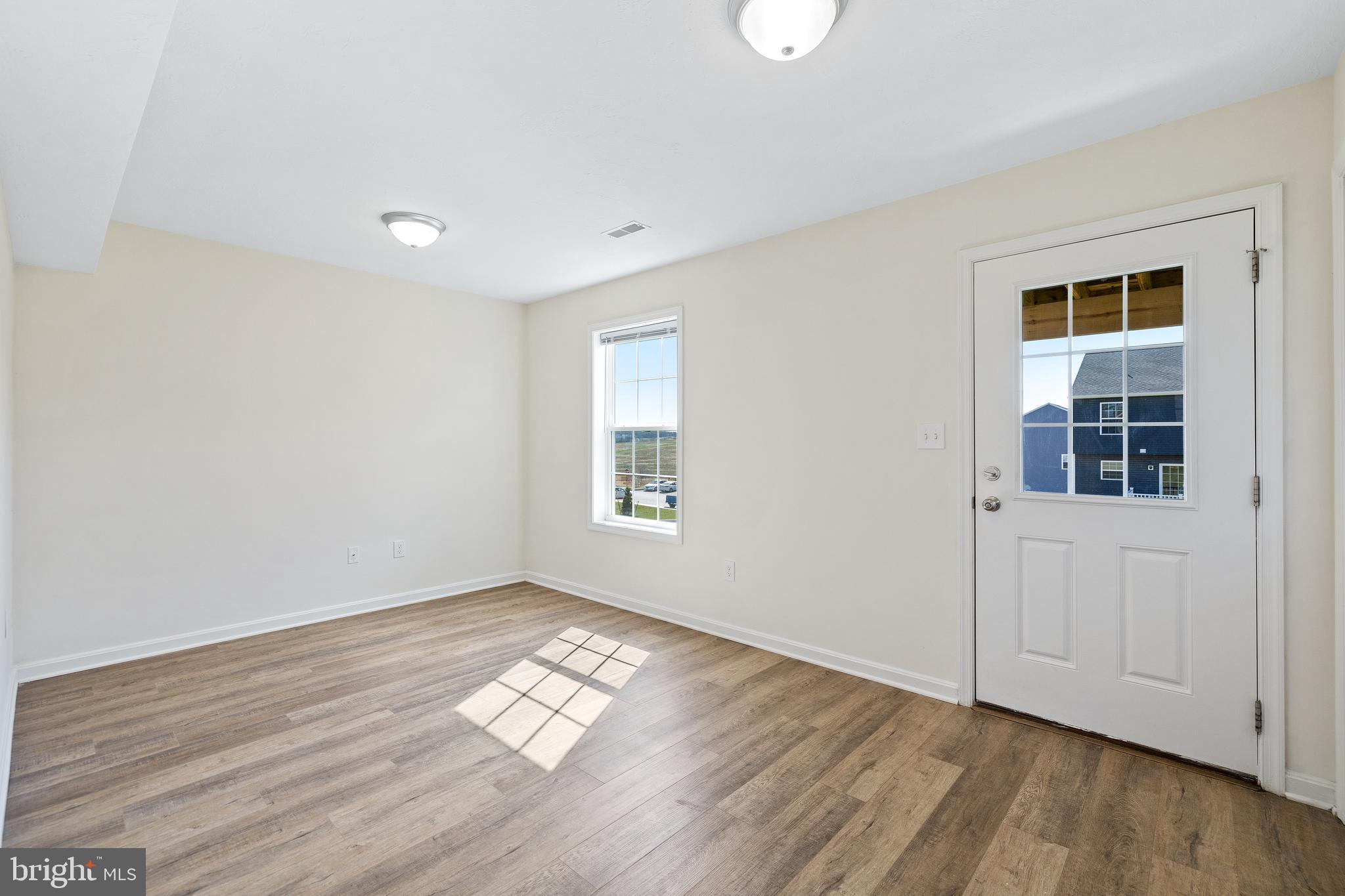 H H Street, Unit 107 Carlisle, PA 17013 - Photo 24 of 26 an empty room with wooden floor and windows