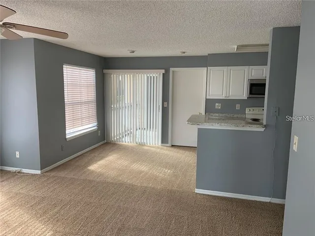 a view of kitchen with a sink cabinet and window
