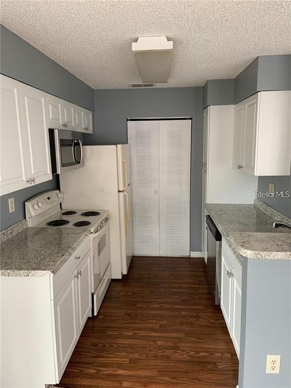 1055 South Hiawassee Road, Unit 2012 Orlando, FL 32835 - Photo 5 of 19 a kitchen with stainless steel appliances granite countertop a sink stove and refrigerator