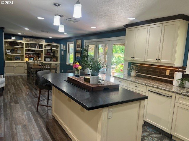 187 Greenvale Drive Springfield, OR 97477 - Photo 4 of 36 a kitchen with kitchen island granite countertop a stove a sink a dining table and chairs with wooden floor