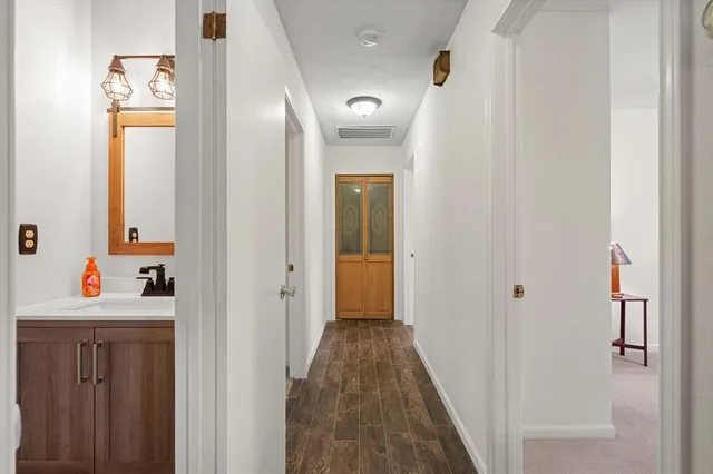 a view of a hallway view with wooden floor and closet area