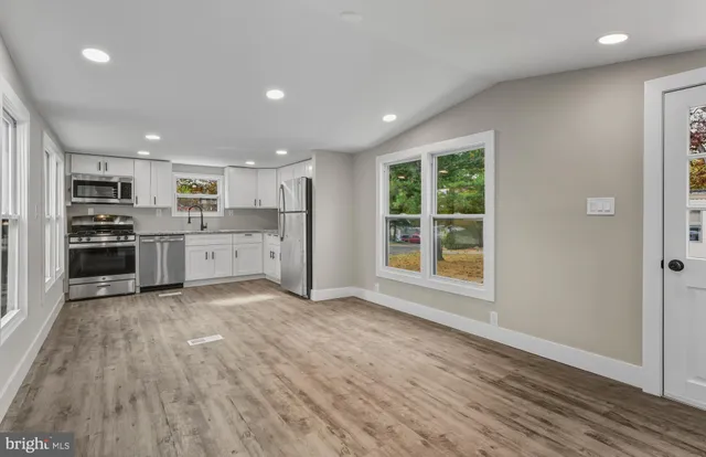 a view of kitchen with wooden floor and electronic appliances