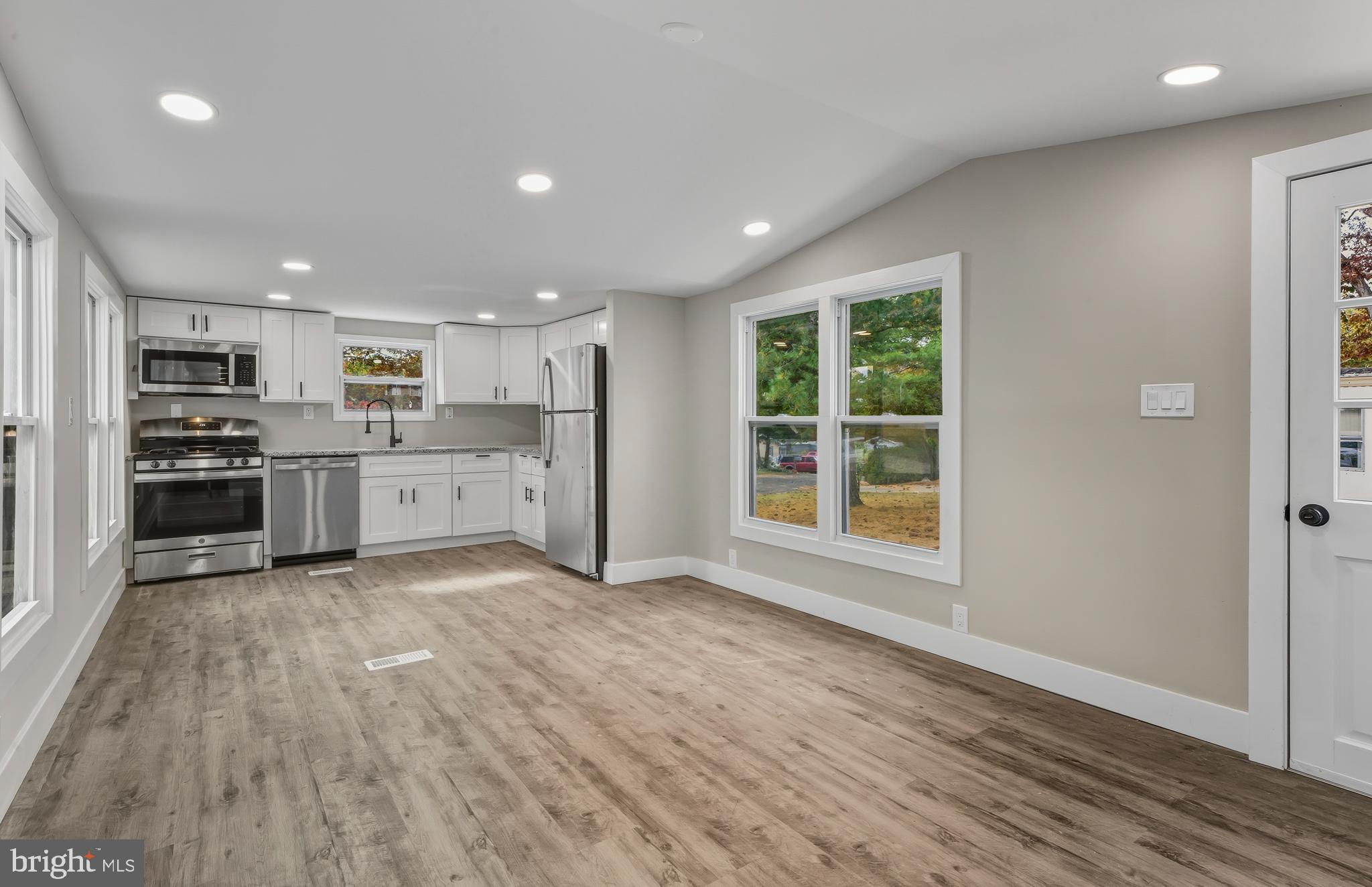 a view of kitchen with wooden floor and electronic appliances