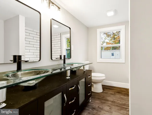 a bathroom with a double vanity sink toilet and a mirror