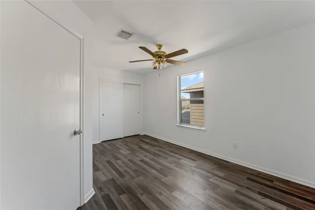 an empty room with a window and a fan