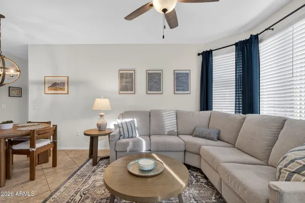 a view of a dining room and livingroom with furniture a rug a kitchen island and a chandelier