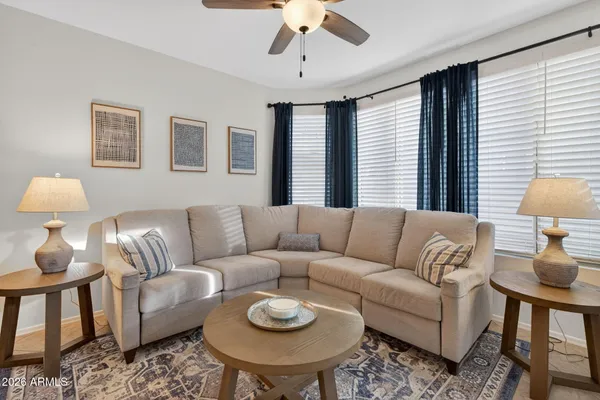 a living room with furniture a flat screen tv and a large window