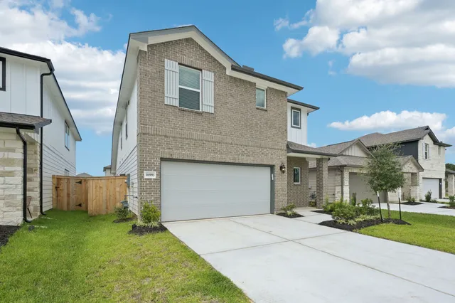 a front view of a house with a yard and trees