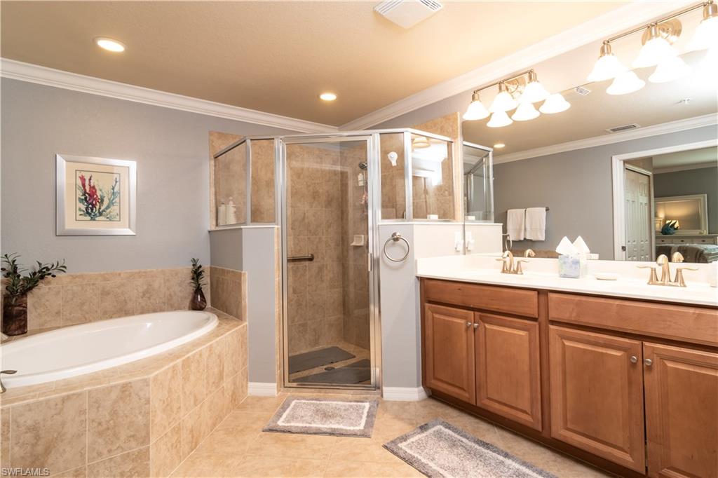 7878 Clemson Street, Unit 101 Naples, FL 34104 - Photo 12 of 18 a bathroom with a tub a sink shower and mirror