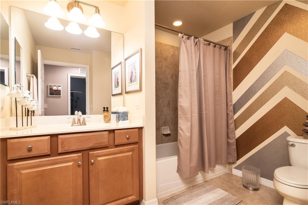 7878 Clemson Street, Unit 101 Naples, FL 34104 - Photo 15 of 18 a view of a bathroom with a sink a mirror and a toilet