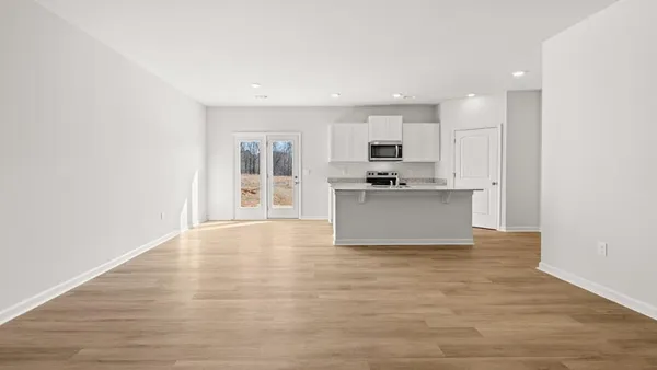 a view of kitchen with granite countertop cabinets and refrigerator