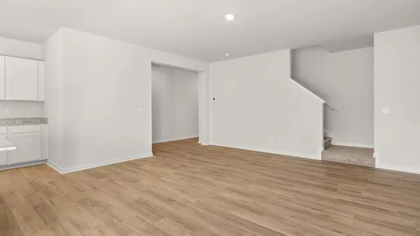 a view of an empty room with wooden floor and closet