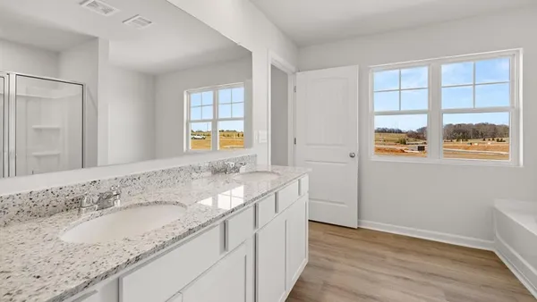 a bathroom with a granite countertop sink and a window