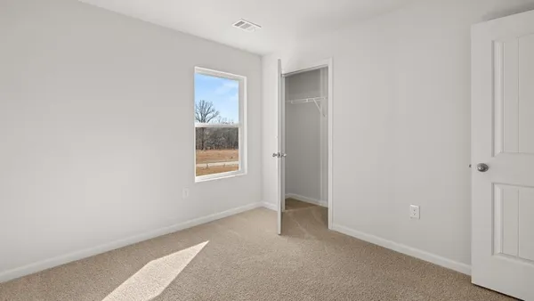 an empty room with windows and closet