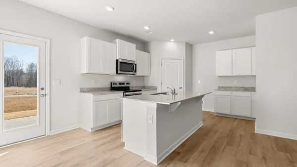 a kitchen with kitchen island granite countertop a sink appliances cabinets and a counter top space