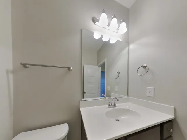a bathroom with a toilet a sink and a mirror