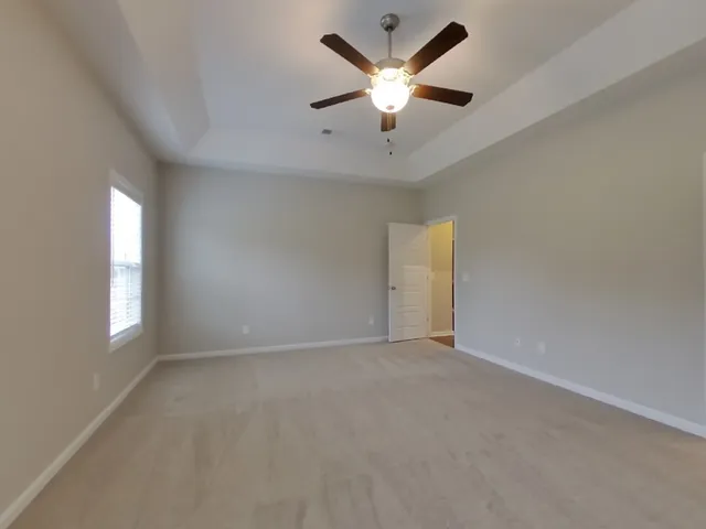 an empty room with windows and ceiling fan