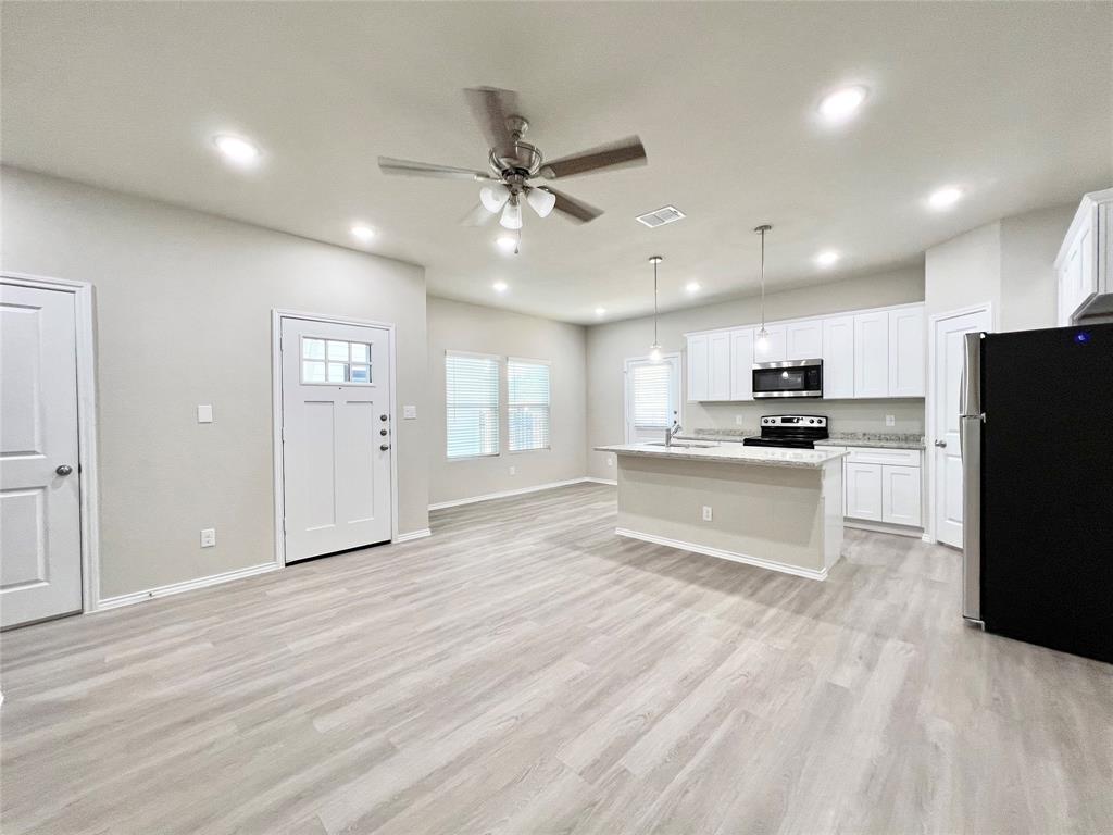 3501 East Renfro Street, Unit 611 Burleson, TX 76028 - Photo 10 of 35 Kitchen with stainless steel appliances, an island with sink, ceiling fan, white cabinets, and hanging light fixtures