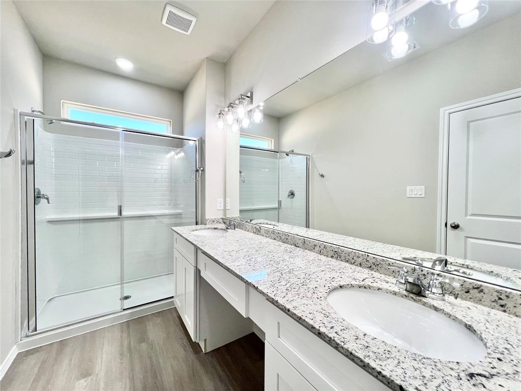 3501 East Renfro Street, Unit 611 Burleson, TX 76028 - Photo 32 of 35 a bathroom with a granite countertop sink a large mirror and a shower