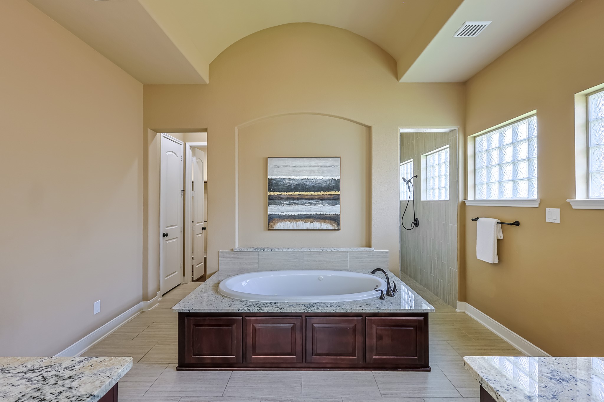 515 Mill Creek Road Pinehurst, TX 77362 - Photo 26 of 48 This spacious bathroom features a luxurious soaking tub with elegant granite countertops and rich wood cabinetry.
