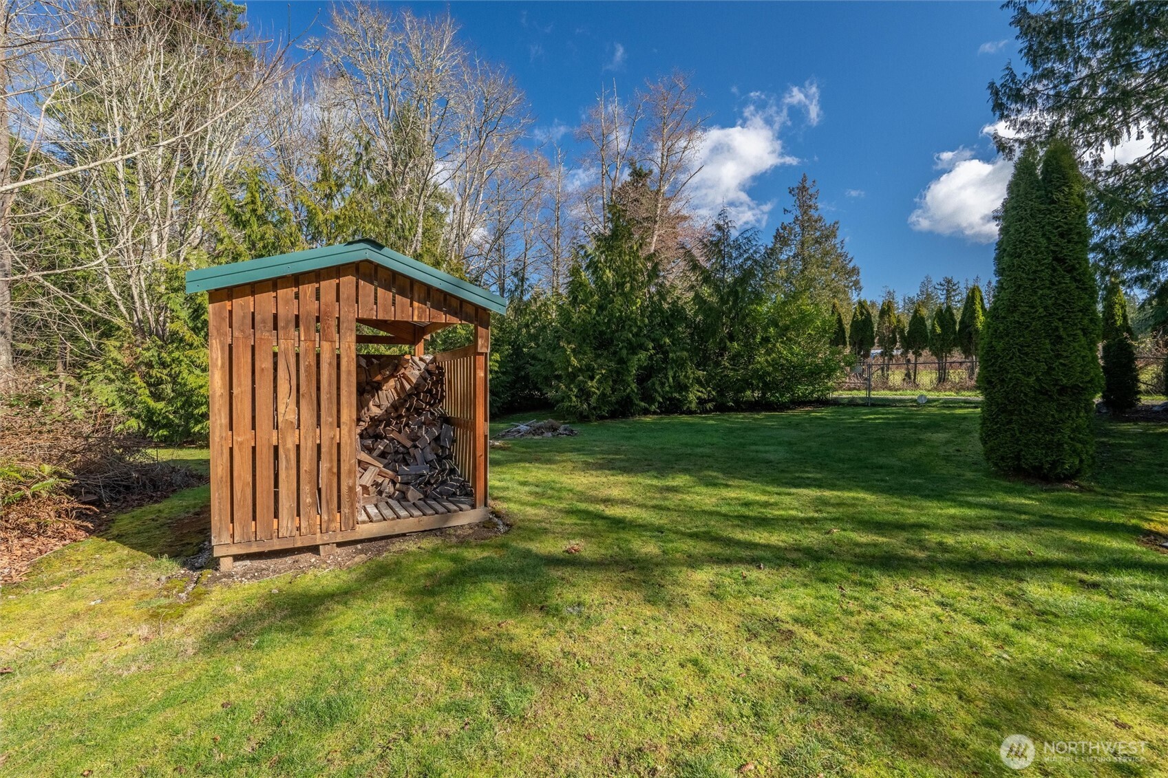 16059 Snee Oosh Road La Conner, WA 98257 - Photo 32 of 40 a view of a wooden house with a big yard and large trees