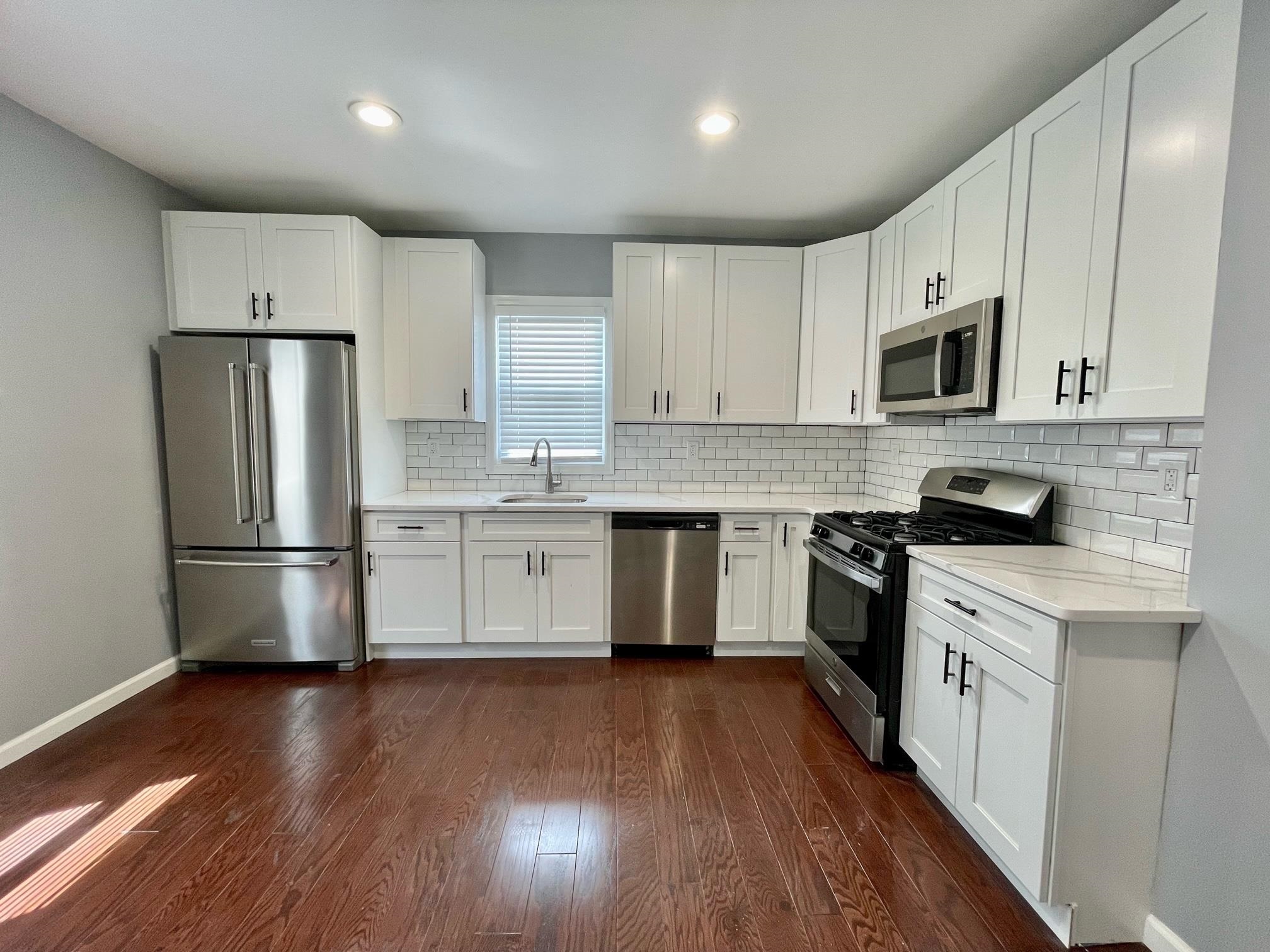 243 Hamilton Place Hackensack, NJ 07601 - Photo 2 of 8 a kitchen with stainless steel appliances a refrigerator sink and cabinets