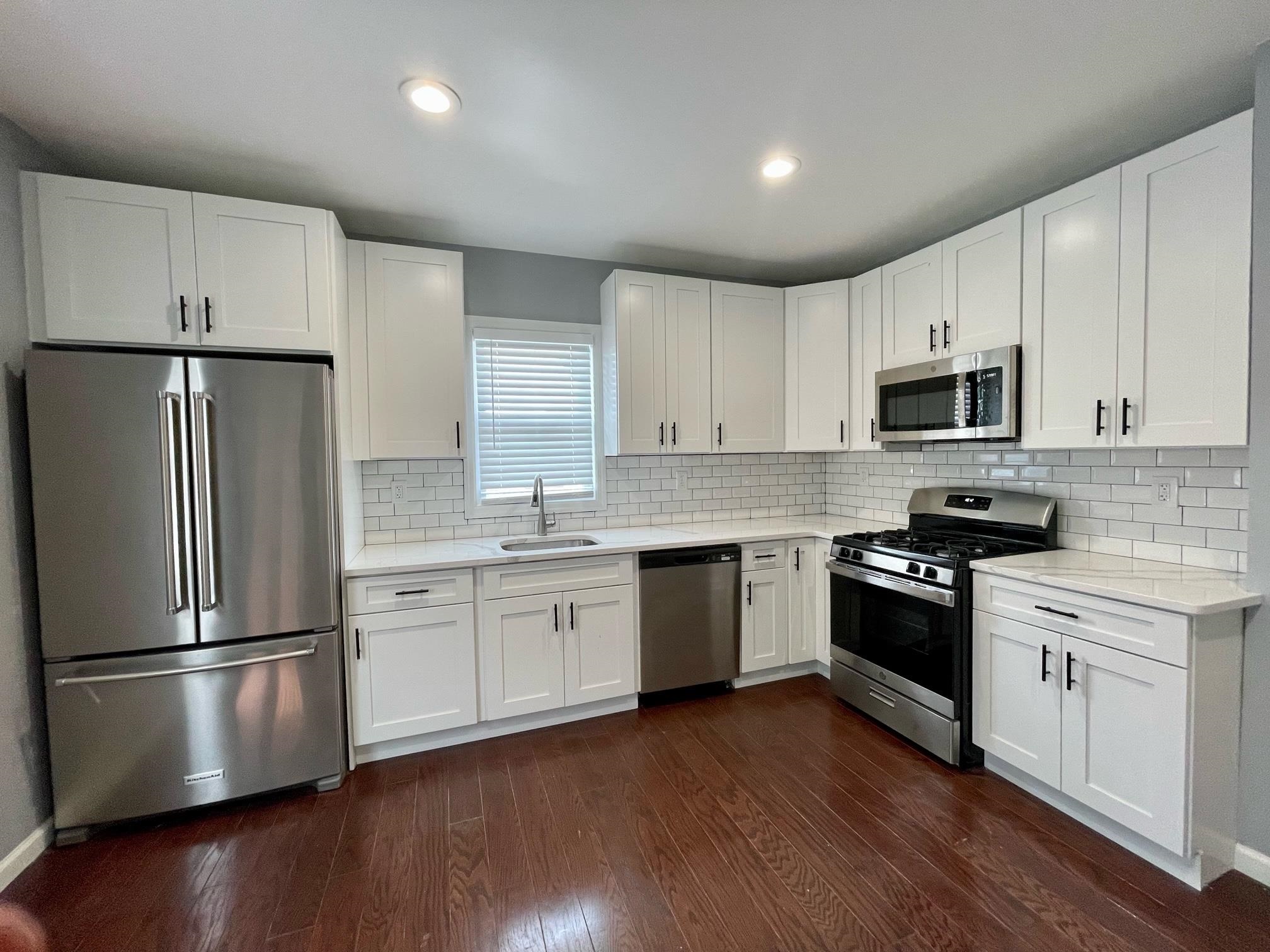 243 Hamilton Place Hackensack, NJ 07601 - Photo 3 of 8 a kitchen with granite countertop white cabinets and stainless steel appliances