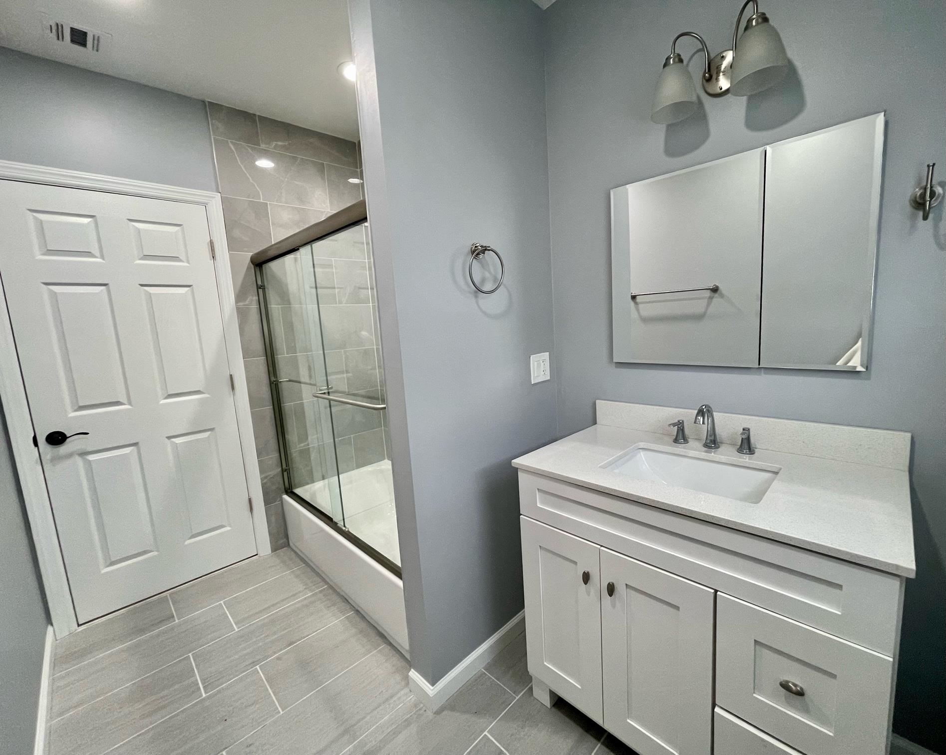 243 Hamilton Place Hackensack, NJ 07601 - Photo 5 of 8 a bathroom with a sink a mirror and a shower