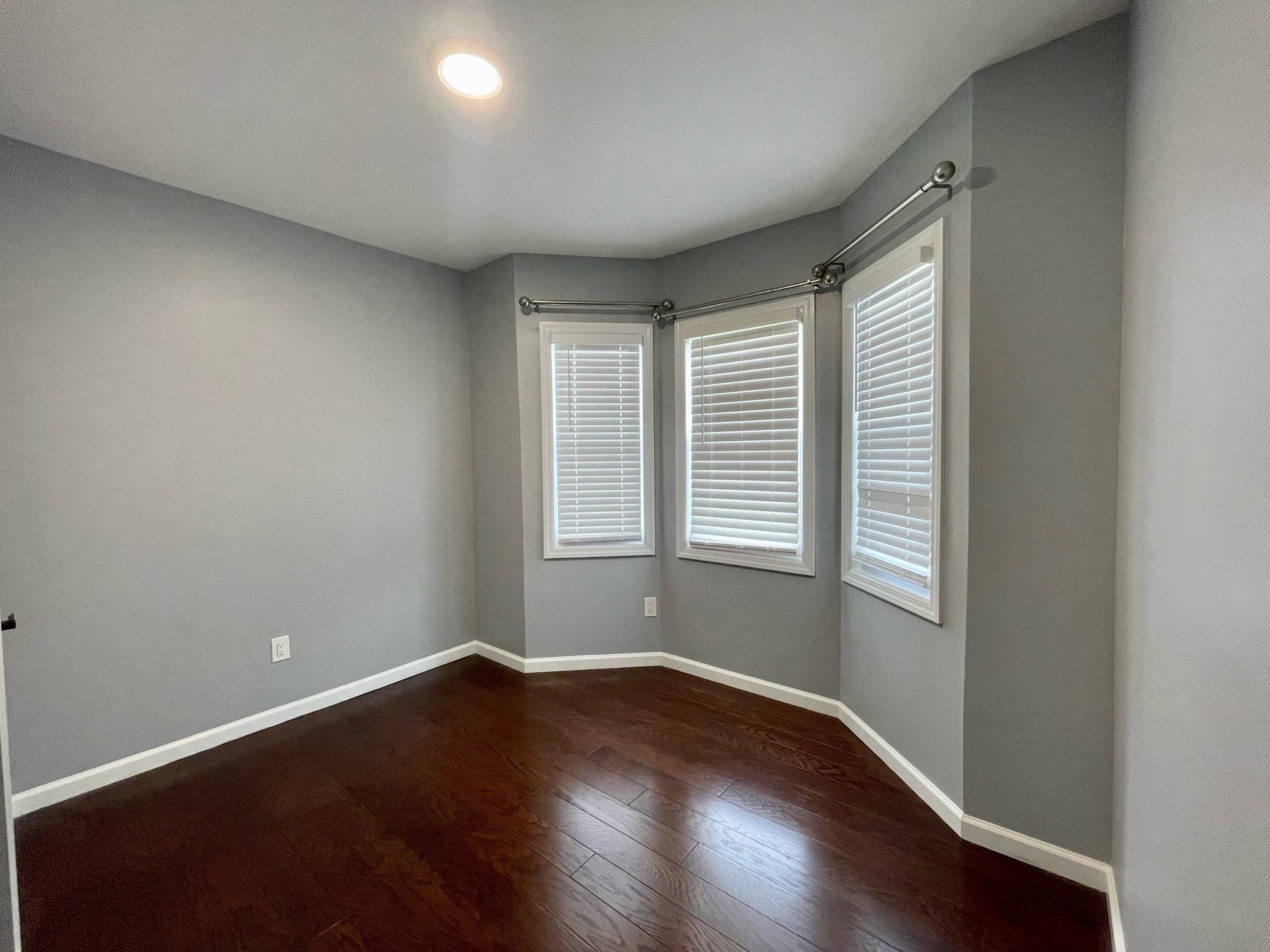 243 Hamilton Place Hackensack, NJ 07601 - Photo 6 of 8 an empty room with wooden floor and windows