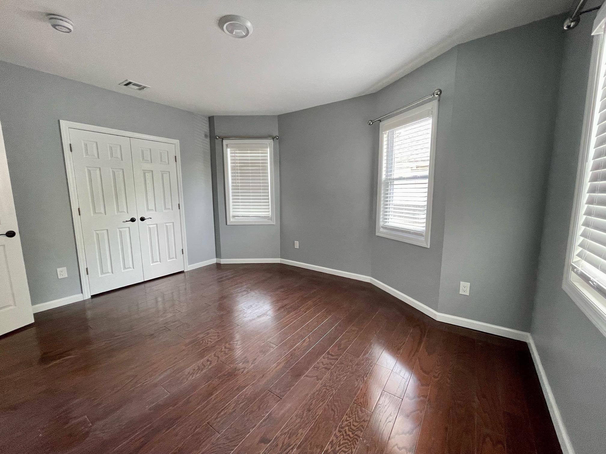 243 Hamilton Place Hackensack, NJ 07601 - Photo 7 of 8 an empty room with wooden floor and windows
