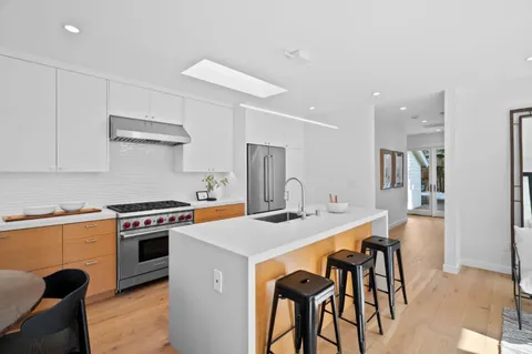 a kitchen with a table chairs sink and cabinets
