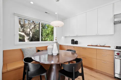 a kitchen with stainless steel appliances a stove and white cabinets