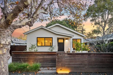 a view of a patio with table and chairs and couches with wooden floor and fence