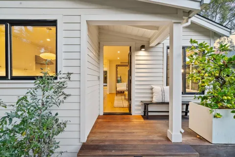 a view of a patio with table and chairs with wooden floor and fence