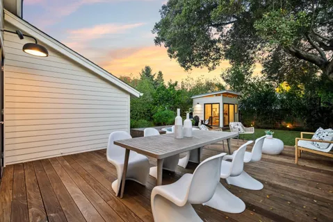 a view of a patio with table and chairs potted plants and wooden fence