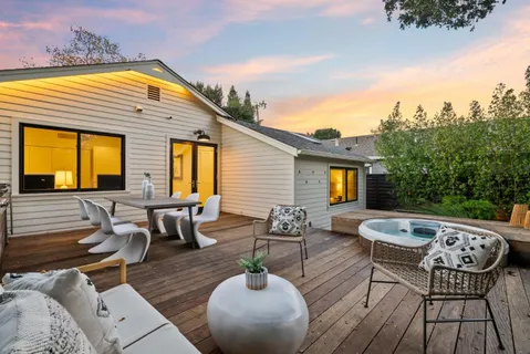 a view of a roof deck with chair and tables