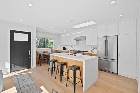 a kitchen with stainless steel appliances a table and chairs