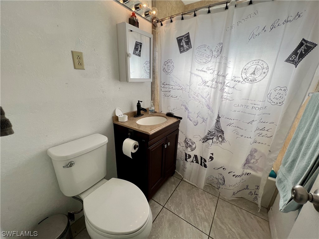 24 Alabama Road South Lehigh Acres, FL 33936 - Photo 12 of 17 a bathroom with a toilet sink and shower