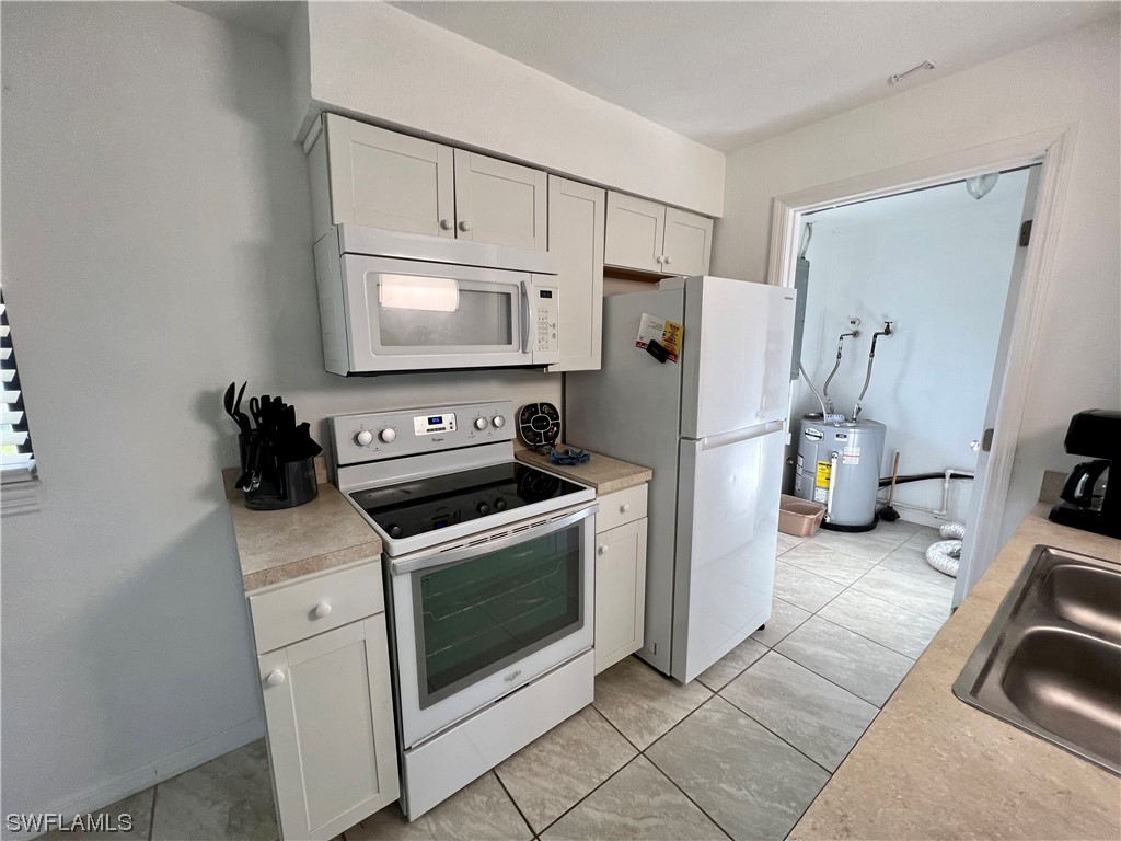 24 Alabama Road South Lehigh Acres, FL 33936 - Photo 5 of 17 a kitchen with a refrigerator stove and white cabinets