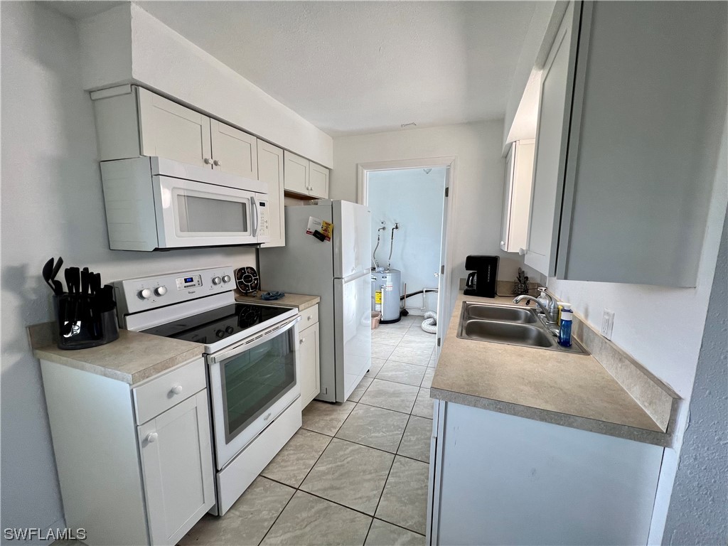 24 Alabama Road South Lehigh Acres, FL 33936 - Photo 8 of 17 a kitchen with a sink appliances and cabinets
