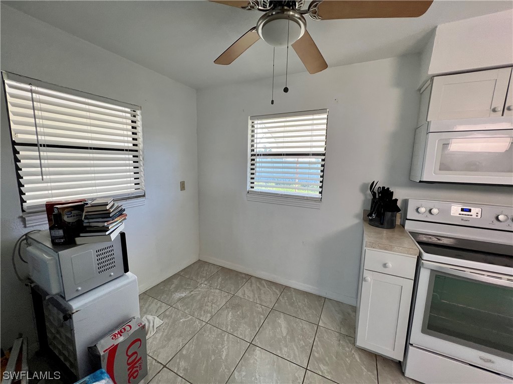 24 Alabama Road South Lehigh Acres, FL 33936 - Photo 9 of 17 a kitchen with a stove and a microwave
