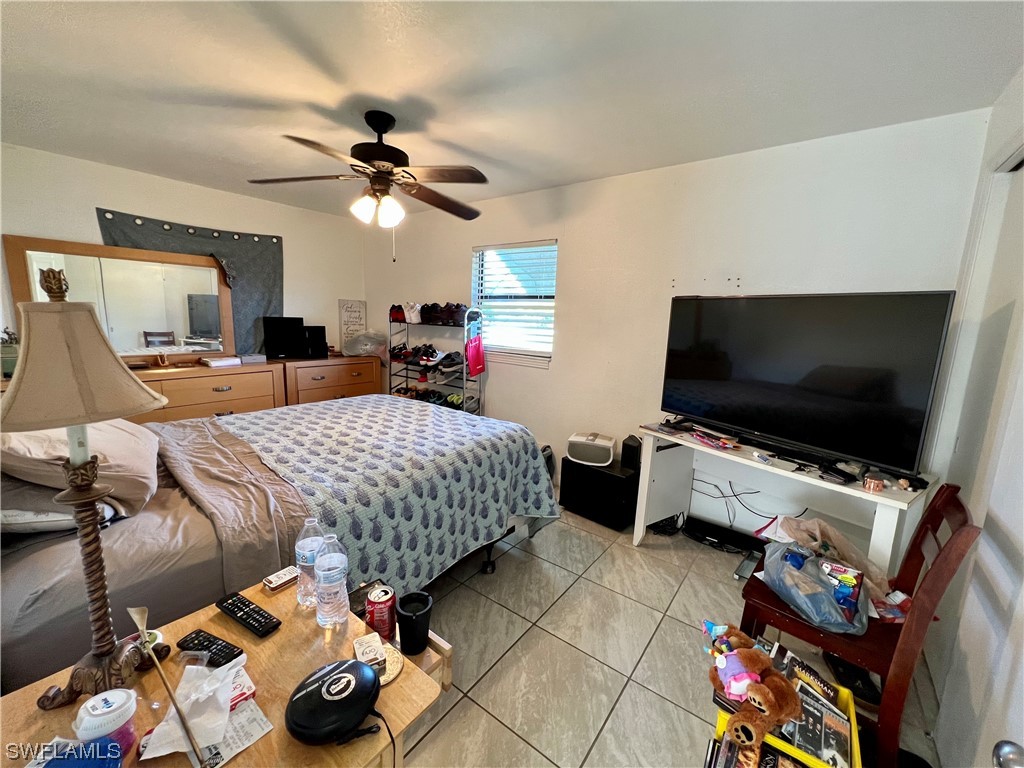 24 Alabama Road South Lehigh Acres, FL 33936 - Photo 10 of 17 a bedroom with furniture and a flat screen tv