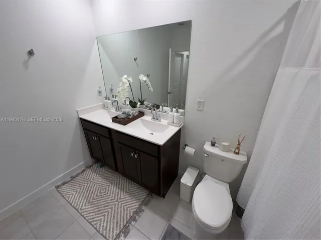 a bathroom with a double vanity sink toilet and mirror