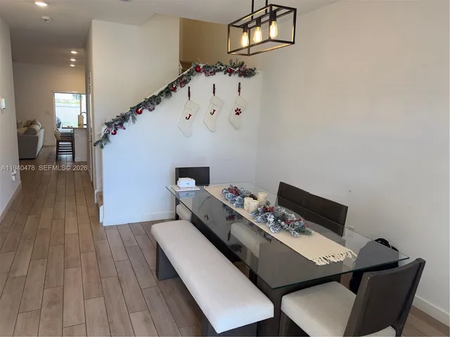 a kitchen with stainless steel appliances a dining table a refrigerator and a stove top oven