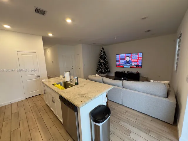 a view of a hallway with workspace and wooden floor