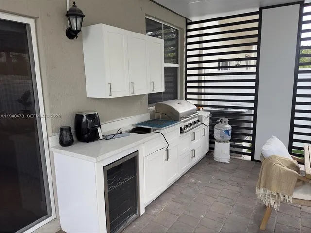 a kitchen with kitchen island stainless steel appliances a sink and living room view