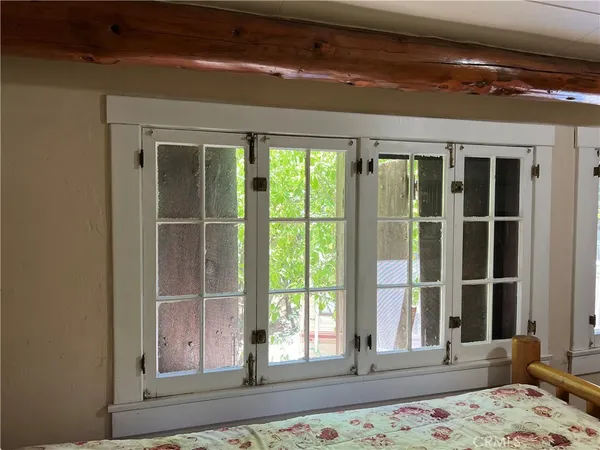 a view of a bedroom with wooden floor and a window