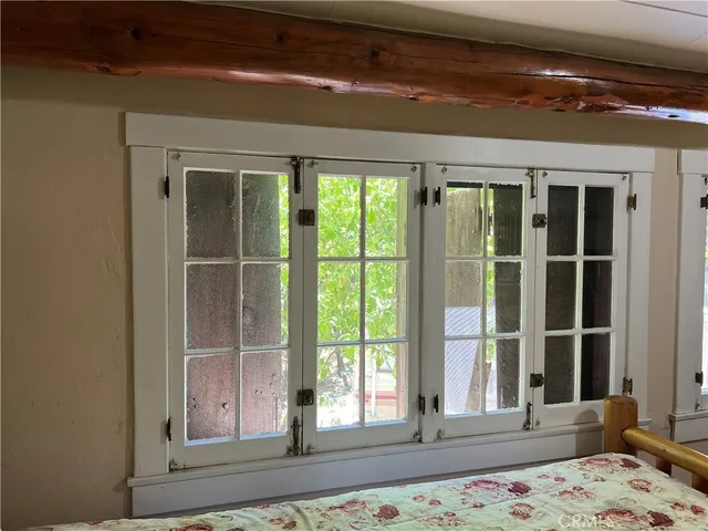a view of a bedroom with wooden floor and a window