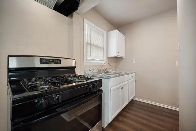 a kitchen with a stove and white cabinets